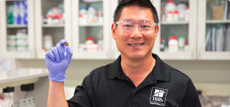 Een voedingswetenschapper van Hill's houdt dierenvoer vast in een laboratorium